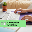 Person using a computer with a 'Computer Literacy' label on a desk.