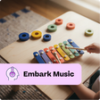 Child playing with a colorful wooden xylophone on a table, with 'Embark Music' branding.